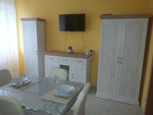 een eetkamer met een tafel en een tv aan de muur bij Szinva Apartman Miskolc in Miskolc