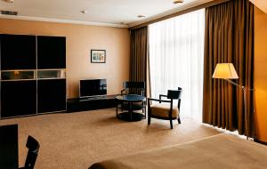 a hotel room with a desk and a table and chair at Lavina Park Hotel in Dnipro