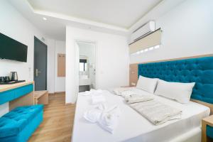 a bedroom with a white bed with a blue headboard at Hotel Medusa in Skala Prinou