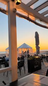 a deck with tables and chairs on the beach at Svetes house - Garden & BBQ & Parking in Liepāja
