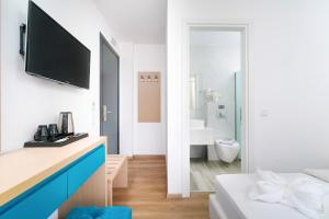 a white room with a bed and a bathroom at Hotel Medusa in Skala Prinou