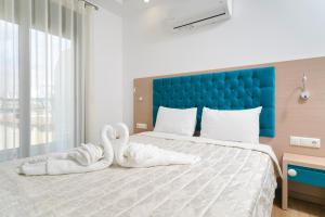 a bedroom with two swans towels on a bed at Hotel Medusa in Skala Prinou +45 photos