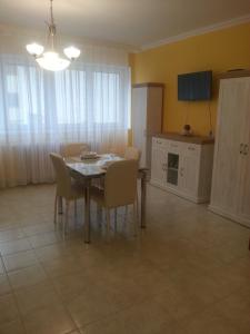 a kitchen and dining room with a table and chairs at Szinva Apartman Miskolc in Miskolc