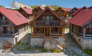 a group of wooden houses with red roofs at Chale do Avô Chico Penhas da Saúde in Penhas da Saúde