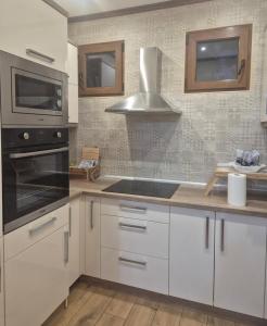 a kitchen with white cabinets and a stove top oven at Vila Lenka in Rtanj