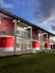 a red and white building with balconies on it at Suítes FM in Cavalcante