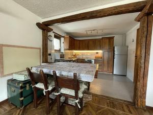 a kitchen with a table and chairs and a refrigerator at Central Spacious Apartment, Mountain Views in Sauze d'Oulx