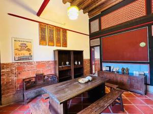 a room with a table and benches in a building at Kinmen Jinyuge Heritage B&B- Shuitou Minnan Village in Hsia-shih