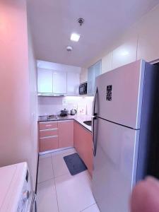 a kitchen with a white refrigerator and white cabinets at 8 Newtown boulevard in Punta Engaño