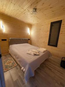 a bedroom with a bed in a wooden cabin at Банрхаус in Cholpon-Ata