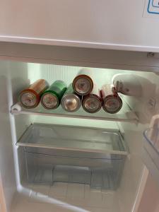 a refrigerator filled with bottles and cans of food at Банрхаус in Cholpon-Ata