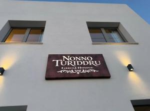 a sign on the side of a building with two windows at Nonno Turiddru Guest House in Marsala