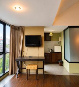 a living room with a desk and a television at Mandala House, Chiang Mai in Chiang Mai