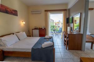 a bedroom with a bed and a desk and a balcony at Iraklis Hotel in Mytikas