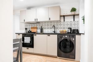 a kitchen with white cabinets and a black dishwasher at MeinZuhause Apartment EG in Bad Pyrmont