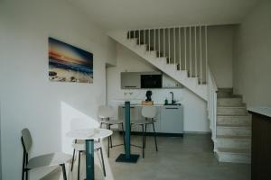 a kitchen with a table and chairs and a staircase at Nonno Turiddru Guest House in Marsala