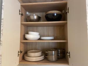 a cupboard with plates and bowls in it at Ventlejas in Strakši +28 photos