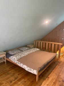 a bed in a room with a wooden floor at Ventlejas in Strakši