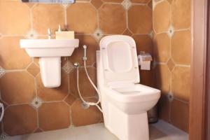 a bathroom with a toilet and a sink at Eden Casa in Mararikulam +33 photos