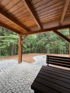 a wooden pavilion with a bench in a park at Chata - TYROLEHAUSE in Martin