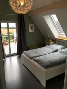 1 dormitorio con cama y lámpara de araña en Haus Charlotte, en Fehmarn