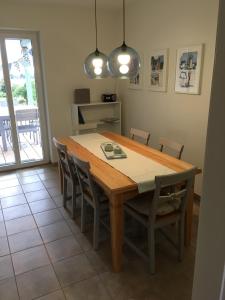 a dining room with a wooden table and chairs at Haus Charlotte in Fehmarn