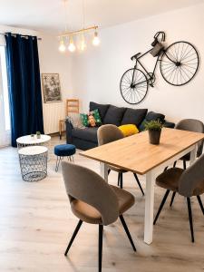 a living room with a table and a bike on the wall at HAPPY HOME COLMAR with PRIVATE PARKING in Colmar
