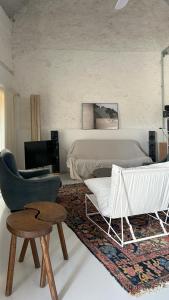 a living room with a bed and a chair at Grange habitée, nature & design in Manou