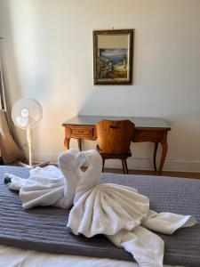 a pile of towels on a bed with a desk at Le Cosy Strasbourg calme et confortable avec parking gratuit, 10 mn du Parlement Européen et du Wacken de 1 à 24 voyageurs in Schiltigheim +108 photos