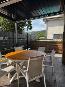 a wooden table and chairs on a patio at el bosc in Sant Jaume de Llierca