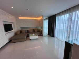 a living room with a couch and a tv at Yenna Apt in Kamala Beach