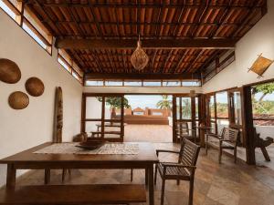 a living room with a wooden table and chairs at Casaboa Casarão Boutique Orla in Itacaré