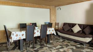 a dining room with a table and chairs and a couch at Lali`s Guest House in Juta in Jut'a
