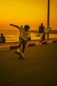 a young man riding a skateboard down a street at Beach Side Imsouane in Imsouane