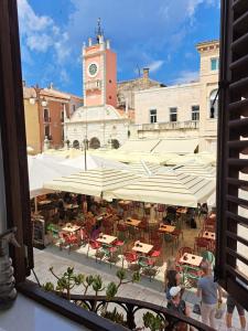 a view of a courtyard with tables and a clock tower at Apartment Agora in Zadar