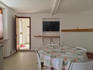 a dining room with a table and a tv at Casa Vacanze Merion in Piticchio