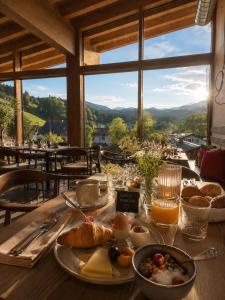 a table with breakfast food on a table with a view at Bayern Resort Hotel - Adults only - mit Zugspitzblick - Eibsee-Nähe - Wellnessbereich - Naturpool im Sommer in Grainau