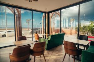 a restaurant with tables and chairs and a view of the ocean at Les Roches De Mazagan in El Jadida