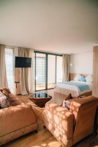 a bedroom with a bed and a couch and a bed at Les Roches De Mazagan in El Jadida