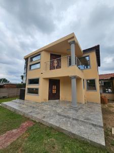 a large yellow house with a balcony at Posimuma Guesthouse Boutique in Centurion