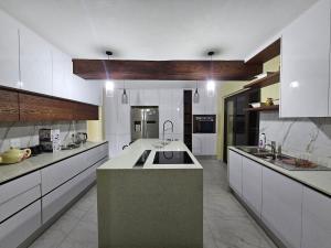 a large kitchen with white cabinets and a large island at Posimuma Guesthouse Boutique in Centurion