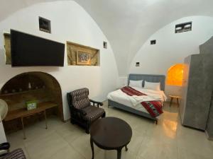 a bedroom with a bed and a chair and a table at Al qasr in Mashabbe Sade