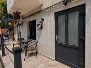 a black door on a building with a table and chairs at Silver Residence Brașov in Braşov