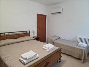 a bedroom with two beds with towels on them at Casa Vacanze Merion in Piticchio