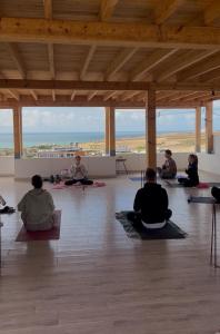 a group of people sitting on the floor in a yoga class at Beach Side Imsouane in Imsouane