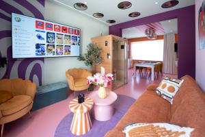 a living room with a couch and a large screen at Capsule Retro Balnéo - Sauna - Billard -Switch 2 in Limelette