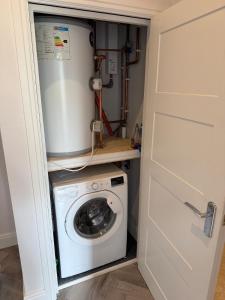 eine Waschmaschine und ein Trockner in einem Hauswirtschaftsraum in der Unterkunft The Loft, FlatB, Redditch in Redditch