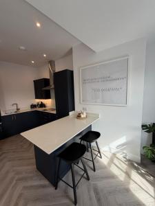 eine Küche mit einer Theke und zwei Hockern in der Unterkunft The Loft, FlatB, Redditch in Redditch