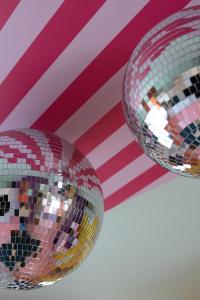 two disco balls hanging from the ceiling with an american flag at Capsule Retro Balnéo - Sauna - Billard -Switch 2 in Limelette