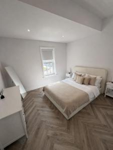ein weißes Schlafzimmer mit einem Bett und einem Fenster in der Unterkunft The Loft, FlatB, Redditch in Redditch